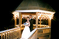 wedding couple in lit gazebo.